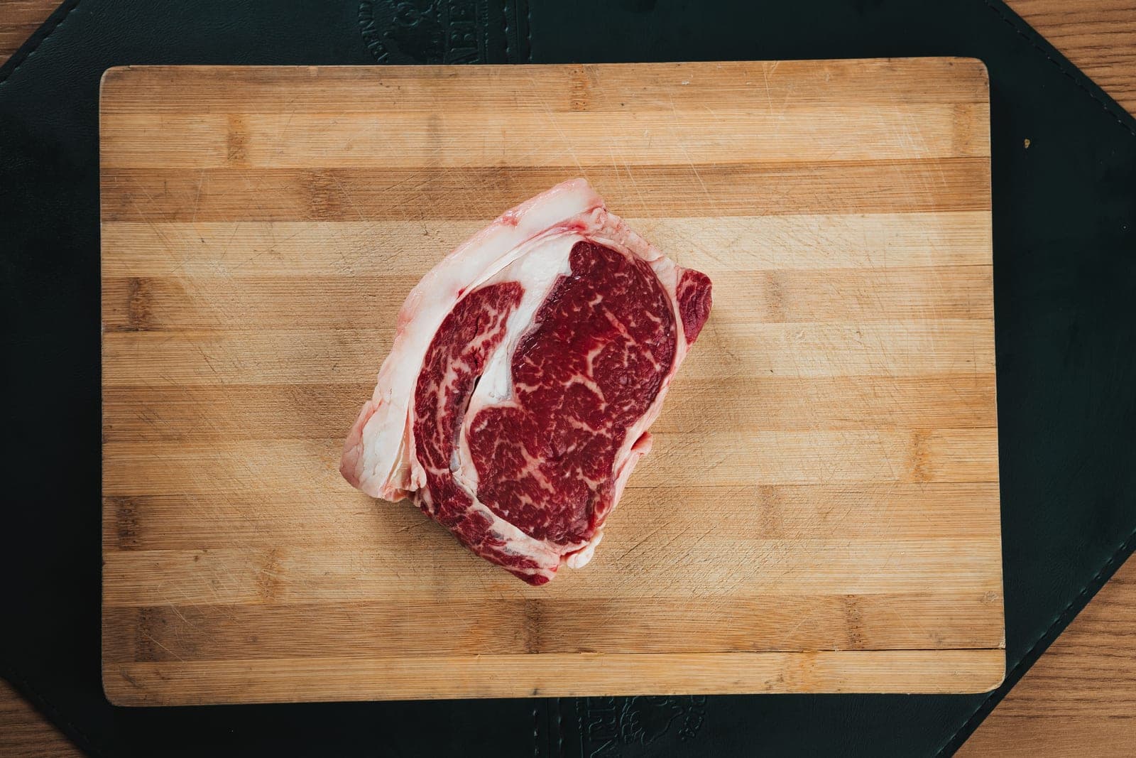 Marbled cut of beef on a wooden cutting board